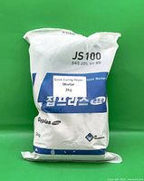 Front view of sealed JS100 repair mortar bag showing 2 kg weight and branding