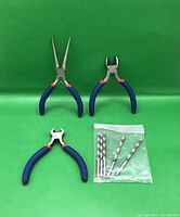 overview of three pliers and bag of four drill bits