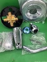 All components laid out including valve body, escutcheon, tub spout, showerhead, arm, flange, hardware