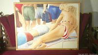 Framed painting on red upholstered bench, full view showing subject and frame