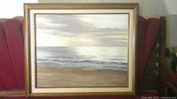 Overall view of framed seascape painting on red chair