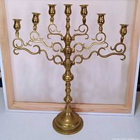 Front view showing seven taper holders and ornate scroll arms