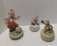 Front view of all three clown music boxes upright