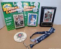All items in lot: two sealed baseball card packs, Cal Ripken Jr. display, Cubs All-Star pin, Rays lanyard