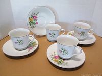 Group view of four cups and saucers showing pattern and quantity
