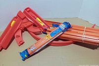 Mixed red Ultimate Garage pieces and bundled orange track including sealed pack