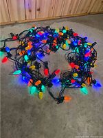 Coiled 100-ft string lights illuminated showing multi-color bulbs