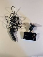 Dash cam with charger cable and suction mount displayed together