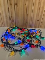 Coiled 32-ft strand with lit multi-colour bulbs on table