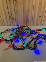 Coiled 32-ft strand of lit multicolour Christmas lights on green wire