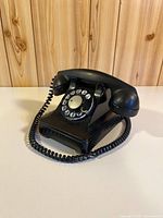 Oblique front view of rotary phone showing dial and body