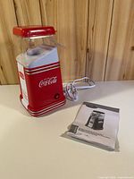 Front view of red Coca-Cola popcorn maker showing logo and overall condition