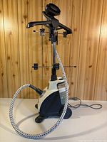 Full view of Conair upright fabric steamer with pole extended, hanger, hose and base visible