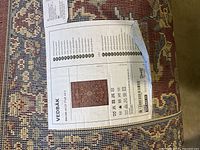 Label on rug showing IKEA VEDBÄK model and care instructions