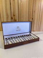 Closed view of open display case showing full set of spoons