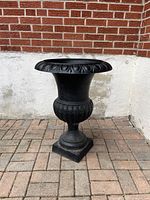 Full front view of black cast-iron urn planter showing overall form
