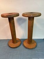 Front view of both wooden bobbins standing upright