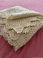 Folded cream crocheted afghan showing texture and thickness
