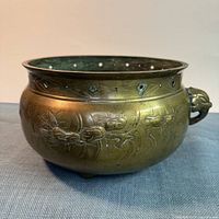 Full view of bronze incense burner showing dragon relief, pierced rim, elephant handle, tripod feet