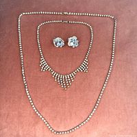 Full view of both necklaces arranged with earrings centered