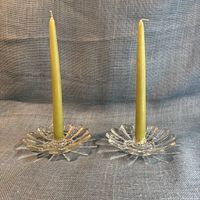 Full view pair of glass sunflower candleholders with tapers inserted