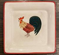 Top view of square ceramic platter showing rooster motif and red rim