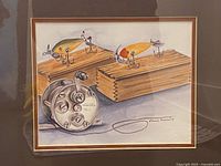 Close view of art image showing fishing lures, wooden boxes, reel and artist signature