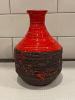 Front view of red lava vase showing full shape and glaze contrast