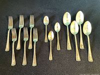 Group shot of forks and spoons on black background
