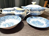Group view of blue and white transferware pieces: covered dish, creamer, sugar bowl, shallow bowl, side plate