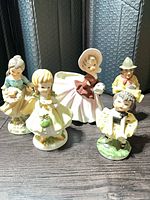 Group shot of all five figurines showing fronts and relative size