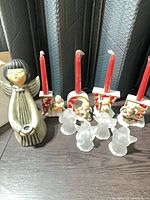 Full lot showing ceramic angel, four letter candle holders with red tapers inserted, four frosted glass angels
