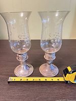 Pair of candlesticks with tape measure indicating height