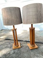 Front view of both wood bamboo-style lamps with shades
