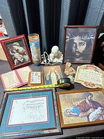 Group view of all framed art, candle, figurines, plaques, booklet and rosary