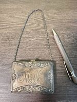 Front view of sterling case showing monogram and chain