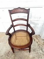 Front view of wooden chair showing cane seat and back design