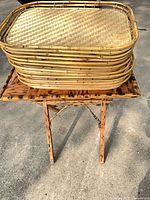 Stack of woven bamboo trays on folding bamboo stand