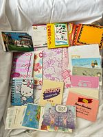 Full lot laid out showing notebooks, letter sets, greeting cards, postcards, envelopes, origami paper