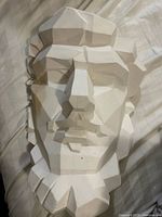 Front view of geometric plaster face sculpture