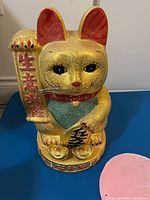 Front view of gold glitter fortune cat piggy bank statue