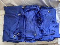 Stack of deep blue-purple grommet curtain panels