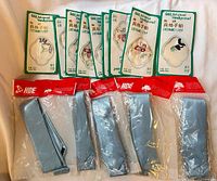 Group shot showing five ties in clear packaging with red headers and eight green packaged handkerchiefs