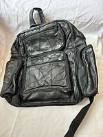 Front view of black patchwork backpack showing pockets and overall design