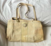Full view of beige Coach tote showing overall style and color