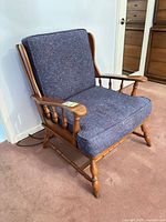 Full view of wooden armchair with cushions