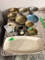 All items arranged on countertop showing platter, bowls, jar, vase
