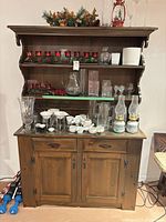 Front view of buffet base and hutch loaded with glassware (contents excluded) showing overall design, doors, drawers, shelves