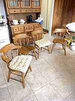 Four wood spindle-back chairs, two with seat pads