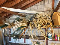 Overall view of shelf showing coiled foam tubing, fencing, piping and metal gutter pieces